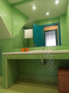 a green bathroom with a sink and a mirror at El encanto de un pueblo 