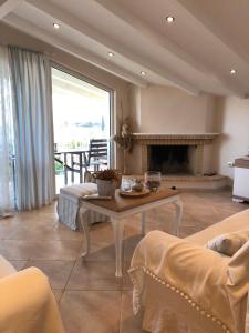 a living room with a table and a fireplace at Eretria’s Villa in Eretria