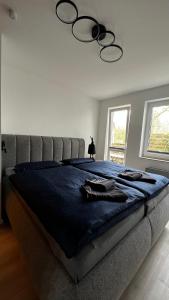 ein Schlafzimmer mit einem großen Bett mit einer blauen Decke in der Unterkunft Haus Malta Wohnung 11, 300m zum Strand in Graal-Müritz