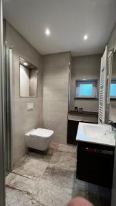 ein Badezimmer mit einer Badewanne, einem WC und einem Waschbecken in der Unterkunft Haus Malta Wohnung 11, 300m zum Strand in Graal-Müritz