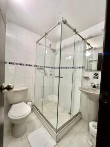 a bathroom with a shower and a toilet and a sink at House Studio Hotel in Bogotá
