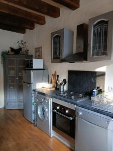 a kitchen with a stove and a washer and dryer at Villa Paris in Prats-du-Périgord