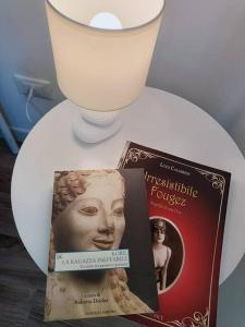 a book and a candle on a white plate at B&B Casa Alinella, Happy and Sustainable Hospitality in Taranto