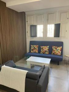 a living room with a blue couch and a table at 180 Home. Rincón de Triana in Seville