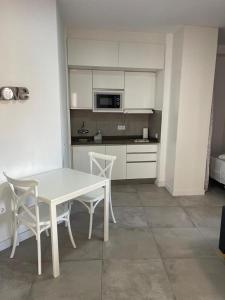 a kitchen with a table and chairs and a microwave at 180 Home. Rincón de Triana in Seville