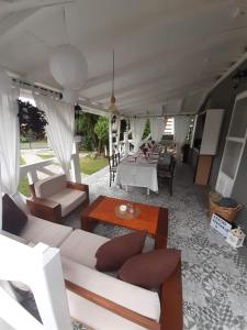 uma sala de estar com sofás brancos e uma mesa em Palić vila Maša pr Emina Stipancevic em Palić