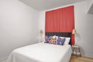 una camera con un letto bianco con una tenda rossa di Relaxing Retreat Near Blossom & CVNP a Hudson