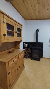uma cozinha com um fogão a lenha num quarto em El Peñoncico em Riópar