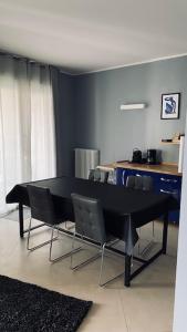 uma sala de jantar com uma mesa preta e cadeiras em Le Chicche del Porto Riviera em Gênova
