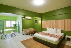 1 dormitorio con paredes verdes, 1 cama y escritorio en GO INN The Grand Palace - Mrt Samyot Station en Bangkok