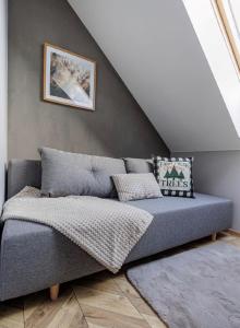 eine Couch in einem Zimmer mit einer Treppe in der Unterkunft TRZY SOSNY LOFT APARTMENTS in Ściegny