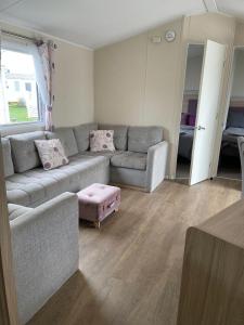 a living room with a couch and a table at Emma's Oasis 4-bedroom caravan at Durdle Door in West Lulworth