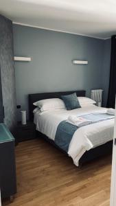 een slaapkamer met een bed en een blauwe muur bij Le Chicche del Porto Riviera in Genua