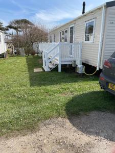 a white mobile home with a porch and a yard at Emma's Oasis 4-bedroom caravan at Durdle Door in West Lulworth