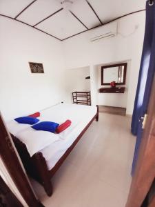 Un dormitorio con una cama con almohadas azules. en Asanka Beach Stay en Mirissa