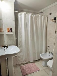 a bathroom with a white shower curtain and a sink at MENDOZA Suites 11 in Mendoza