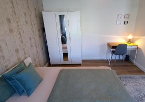 a bedroom with a bed and a desk and a mirror at Elegante Einzimmerwohnung in Flensburg