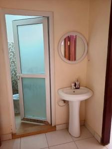 een badkamer met een wastafel en een spiegel bij Carol's homes in Mombasa