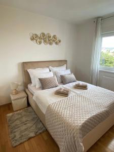 a bedroom with a large white bed with a window at Portview apartment in Rijeka