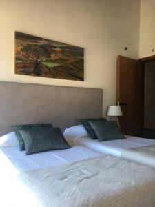 a bedroom with two beds and a painting on the wall at casa das ameias in Folgosa +34 photos