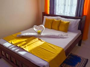 een bed met een hart gemaakt van handdoeken bij Carol's homes in Mombasa
