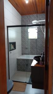 a bathroom with a shower with a sink and a tub at Sonho na Serra Chalé 2 in Gonçalves