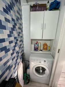 uma lavandaria com uma máquina de lavar roupa na casa de banho em Casa vacanza em Sabaudia