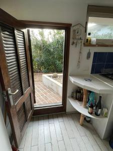 a kitchen with a door leading to a patio at Casa vacanza in Sabaudia