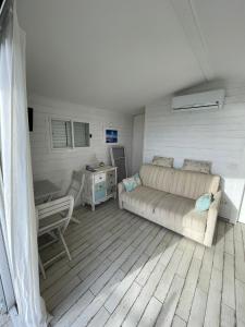 ein Wohnzimmer mit einem Sofa und einem Tisch in der Unterkunft Casa vacanza in Sabaudia