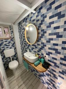 een badkamer met een wastafel en een spiegel bij Casa vacanza in Sabaudia