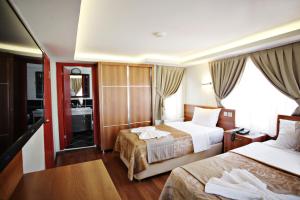 a hotel room with two beds and a bathroom at Taksim Palace Hotel in Istanbul