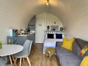 a living room with a couch and a bed in a room at Abbey farm luxury glamping in Rhuddlan
