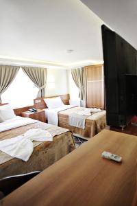 a hotel room with three beds and a flat screen tv at Taksim Palace Hotel in Istanbul