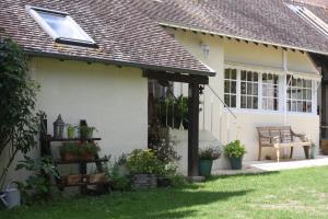 une maison blanche avec un banc dans la cour dans l'établissement la suite Au bon Marechal, à Giverny