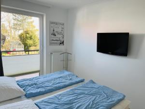 Schlafzimmer mit einem Bett und einem Flachbild-TV in der Unterkunft Baltic Nr. 3 in Scharbeutz