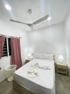 een slaapkamer met een bed met witte lakens en een plafond bij Residencial Bock in El Hoyo del Cacao