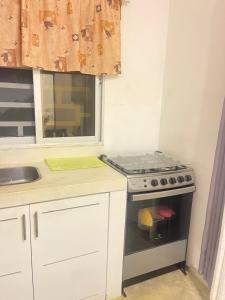 a kitchen with a stove top oven next to a sink at Residencial Bock in El Hoyo del Cacao