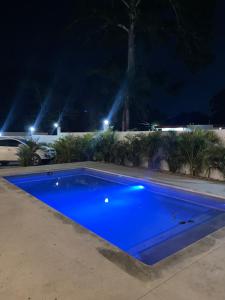 een blauw zwembad met verlichting bij Residencial Bock in El Hoyo del Cacao