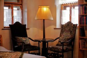 una lámpara y dos sillas en una habitación en Stilvolles Landhaus im Dreiländereck en Felsőszölnök