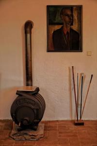 a painting of a man on the wall next to a fireplace at Stilvolles Landhaus im Dreiländereck in Felsőszölnök