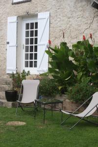 two chairs and a table in front of a house at la suite Au bon Marechal in Giverny