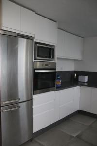 una cucina con frigorifero in acciaio inox e forno a microonde di Villa Darío en Nazaret a Nazaret