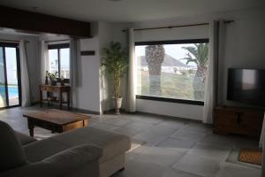 uma sala de estar com um sofá e uma televisão de ecrã plano em Villa Darío en Nazaret em Nazaret