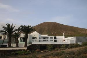 una casa bianca con una montagna sullo sfondo di Villa Darío en Nazaret a Nazaret
