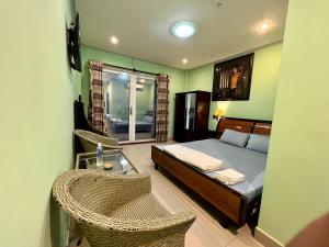 sypialnia z łóżkiem i 2 wiklinowymi krzesłami w obiekcie Bảo Bảo Hotel w mieście Châu Đốc