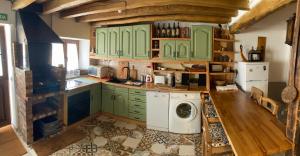 a kitchen with green cabinets and a washing machine at Bellavieja in Villavieja del Lozoya