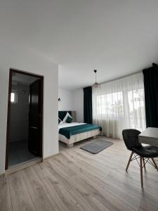 a bedroom with a bed and a table and a chair at Piscul Muntelui in Moieciu de Sus
