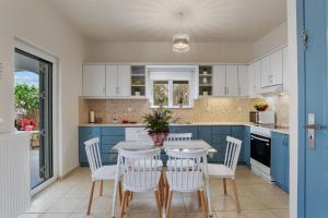 cocina con armarios azules, mesa y sillas en Angels House in Plaka BY APOKORONAS-VILLAS, en Plaka