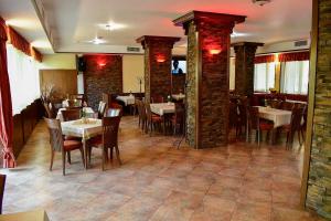 une salle à manger avec des tables et des chaises dans un restaurant dans l'établissement Хотел Ажур, à Kotel