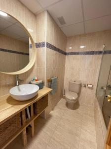 a bathroom with a sink and a toilet and a mirror at Casa cactus Piles Playa in Piles